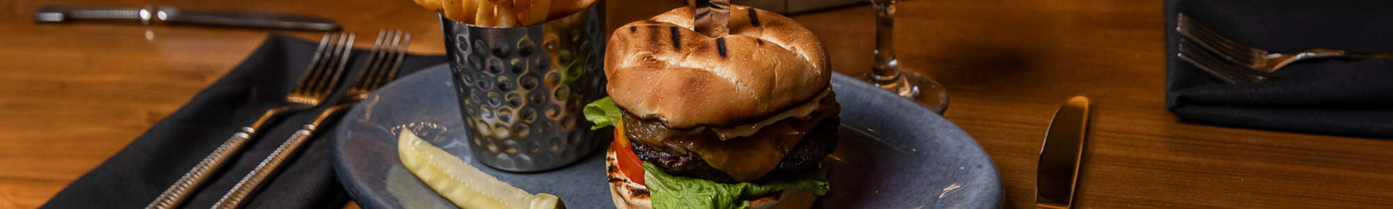Close-up of a gourmet burger with a toasted bun, lettuce, tomato, and a thick patty